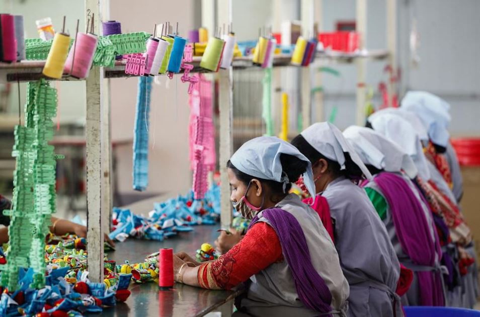 Traditional fashion factory setting with workers putting together cloth clip