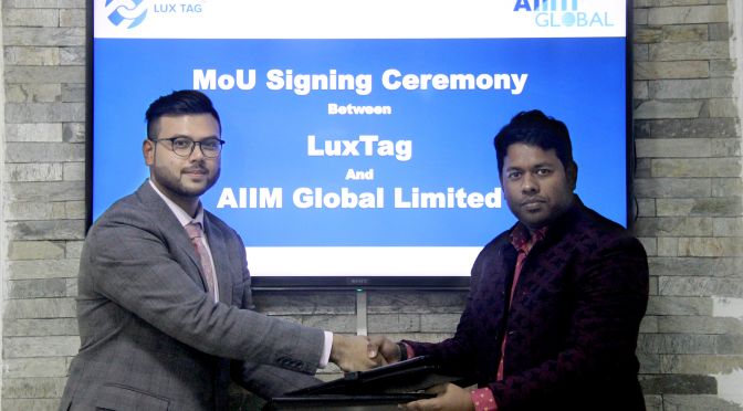 Ahnaf from LuxTag having a handshake with a representative from AIIM Global Limited