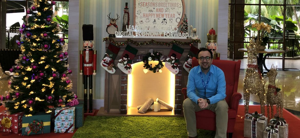 Rene from LuxTag sitting in a room decorated with Christmas theme, wishing you a Happy New Year